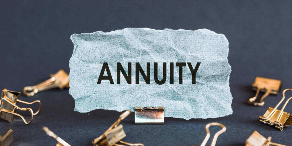 scrap of blue paper with clips on a gray background with the text annuity