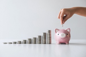 stacking coins pile and Hand putting coin into pink piggy bank for planning step up to growing and savings with money box