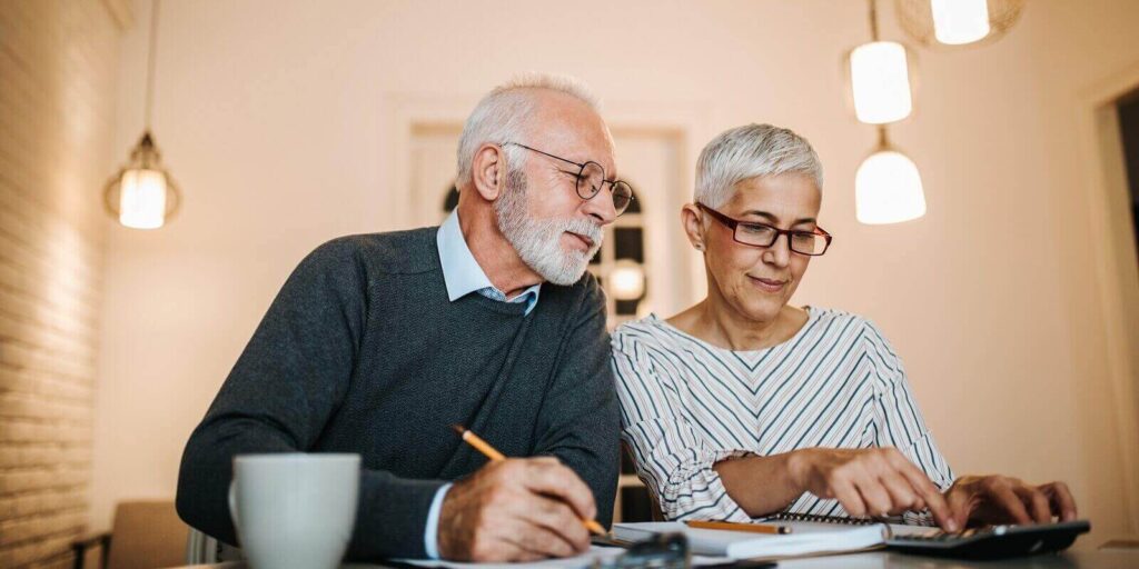 mature couple doing some paperwork and calculations at home