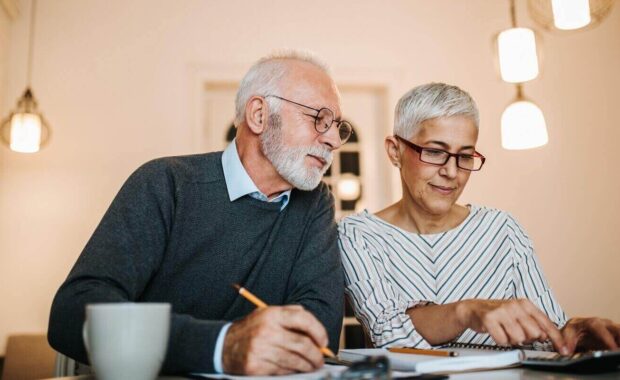 mature couple doing some paperwork and calculations at home