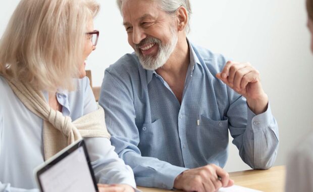 mature couple speaking with young insurance agent