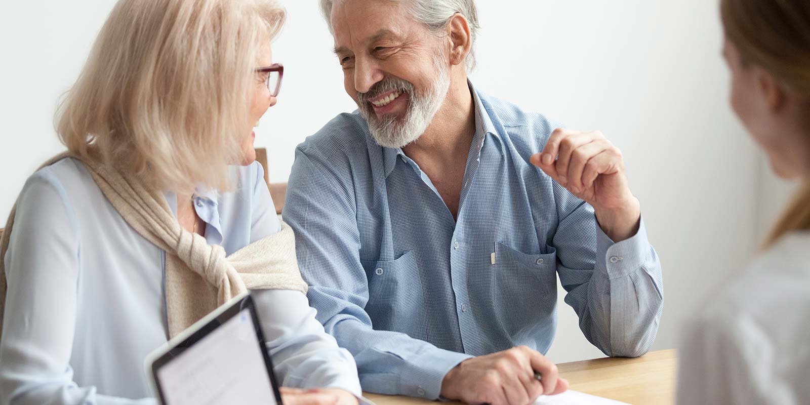 mature couple speaking with young insurance agent