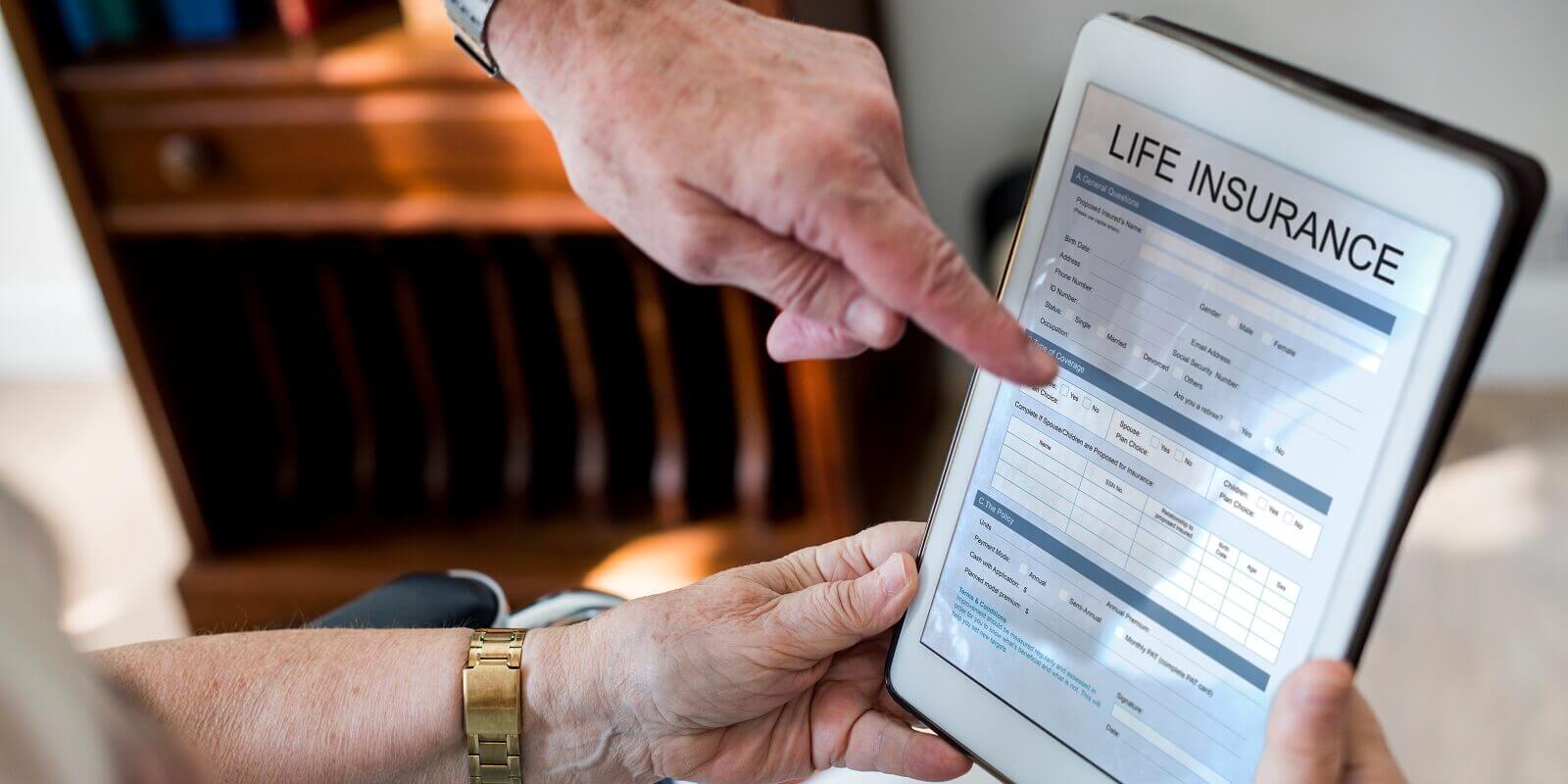 couple reading life insurance form in tablet