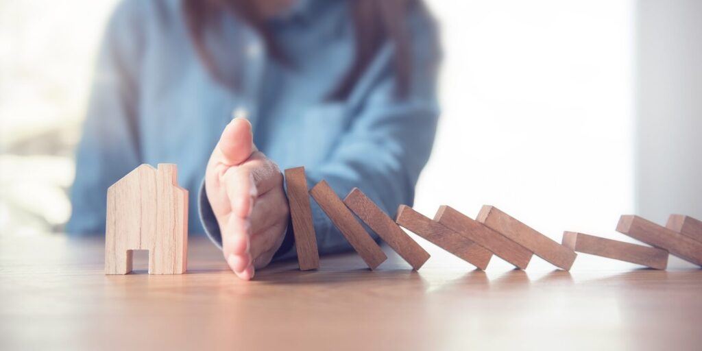 hand stopping risk the wooden blocks from falling on house