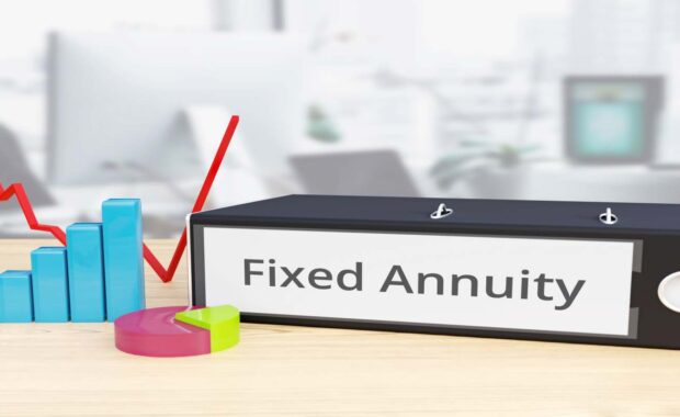 Folder on Desk with Fixed Annuity Label Besides Financial Diagrams