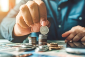 Person Arranging Coins in Stacks Retirement Income Concept