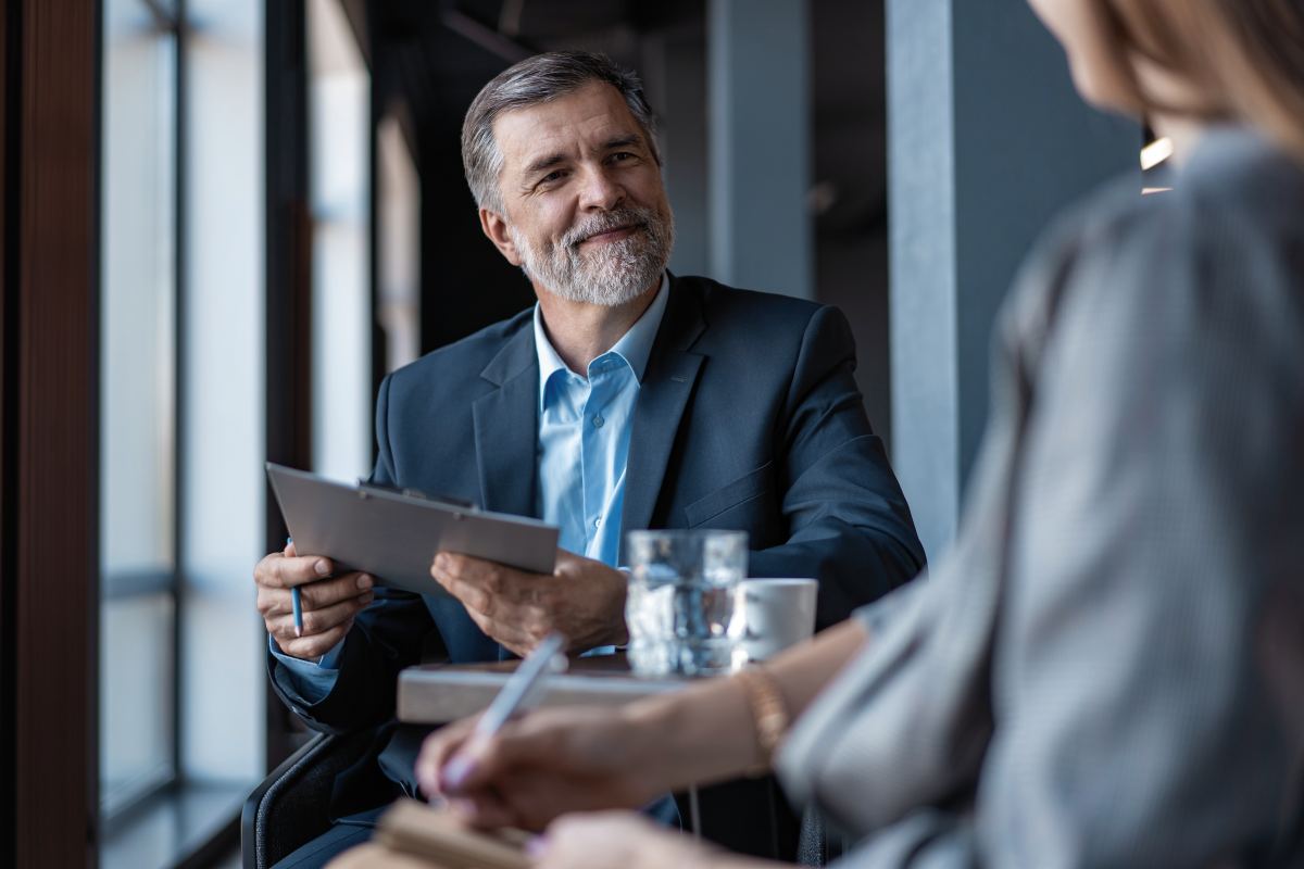 Image of mature businessman interviewing female