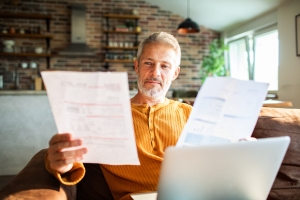 Mature Man Comparing MYGA and Other Investment Documents