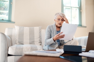 Old Woman Touching Her Head After Finding A Mistake in MYGA Documents