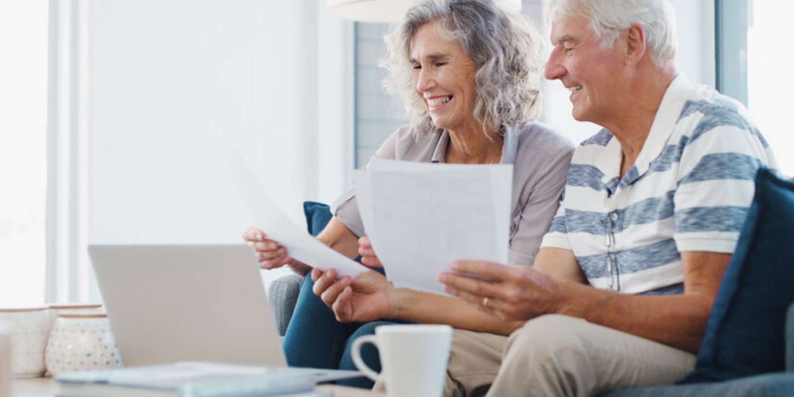 Senior Couple Reviewing MYGA Options with Documents and Laptop for Retirement