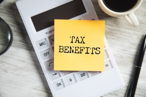 Tax Benefits Text Written on a Slip Over a Calculator